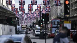 Lalu lintas bergerak melalui Regent Street yang dihiasi di pusat kota London Jumat, 5 Mei 2023. Penobatan Raja Charles III akan berlangsung di Westminster Abbey pada 6 Mei. (AP Photo/Markus Schreiber)