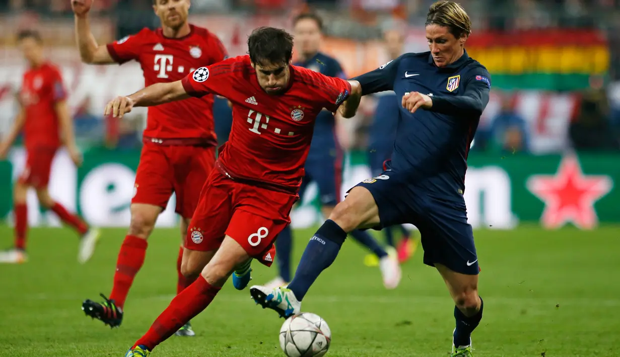 Penyerang Atletico Madrid, Fernando Torres berusaha melewati gelandang Muenchen, Javi Martinez di Liga Champions di Allianz Arena (4/5). Meski kalah 2-1 dari Munchen, Atletico melaju ke final dengan aggregat gol tandang. (Reuters/Michaela Rehle)