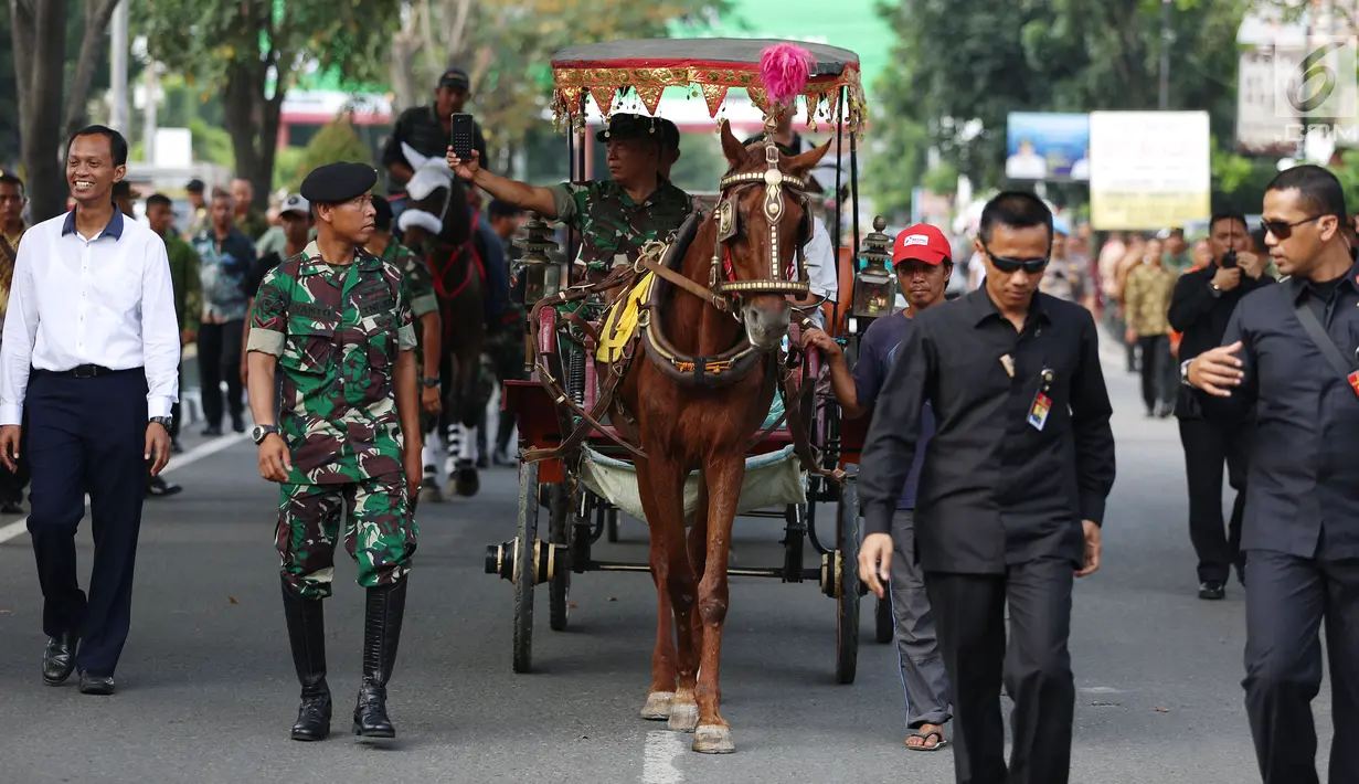 Anggota TNI menaiki andong saat mengikuti geladi resik kirab ngunduh mantu Kahiyang-Bobby di Medan, Rabu (22/11). Nantinya, personel TNI dan Polri yang akan mengikuti kirab budaya menggunakan pakaian adat. (Liputan6.com/Johan Tallo)
