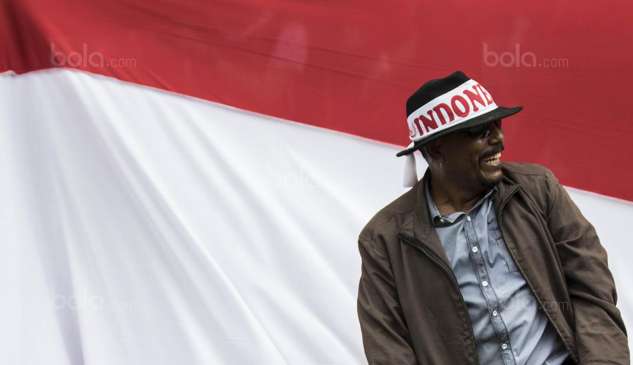 Seorang suporter berada di depan bendera raksasa saat menonton Timnas Indonesia melawan Thailand pada laga SEA Games di Stadion Shah Alam, Selangor, Selasa (15/8/2017). Kedua negara bermain imbang 1-1. (Bola.com/Vitalis Yogi Trisna)