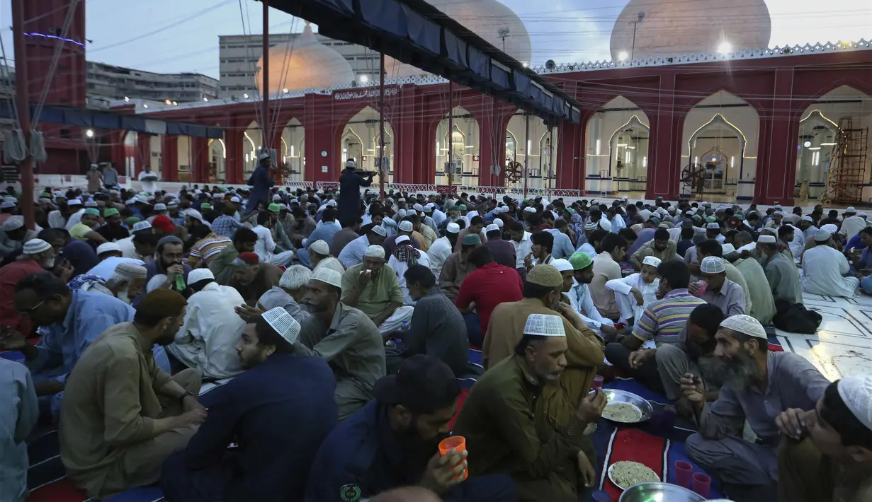 Sejumlah umat Muslim berbuka puasa di masjid, selama bulan suci puasa Ramadhan, di Karachi, Pakistan, Rabu (14/4/2021). Bulan Ramadhan ditandai dengan berpuasa setiap hari dari fajar hingga matahari terbenam. (AP Photo/Fareed Khan)