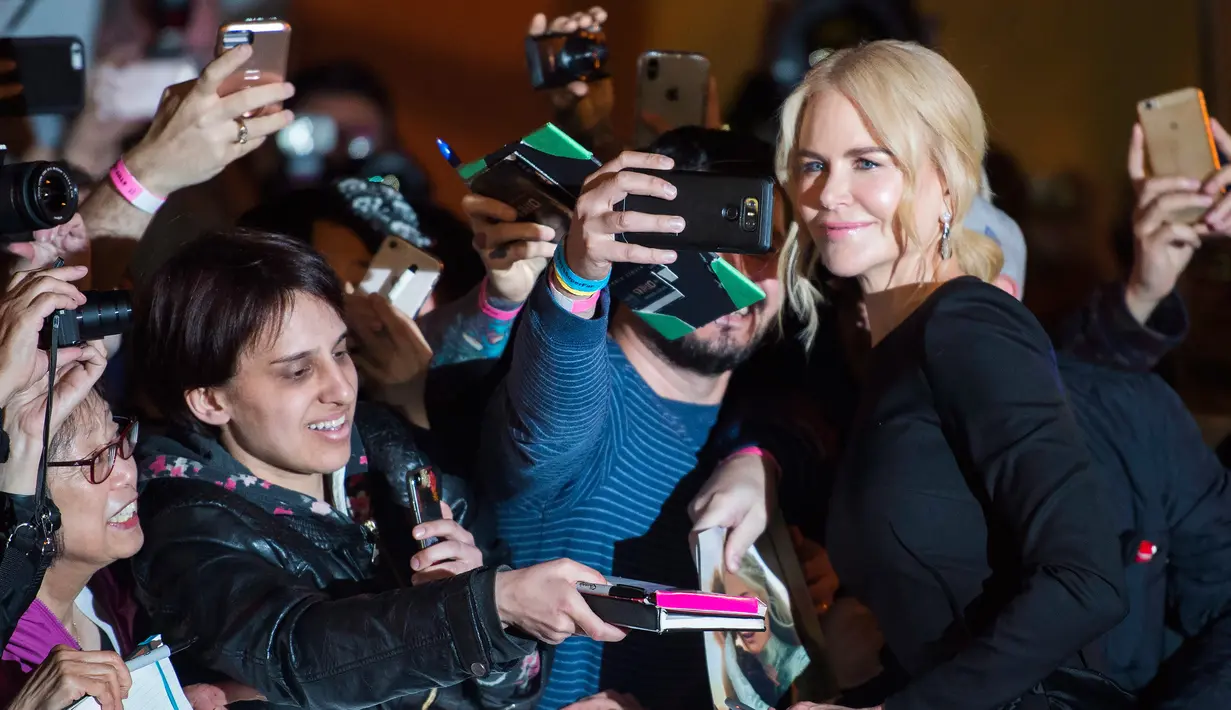 Nicole Kidman menyapa fans saat tiba menghadiri pemutaran film "Boy Erased" selama Toronto International Film Festival 2018 di Toronto, Kanada (11/9). Nicole Kidman tampil cantik dengan gaun hitam di acara tersebut. (AP Photo/Nathan Denette)