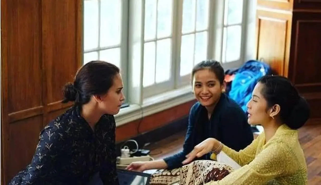 Mengunggah foto dirinya yang sedang syuting film Kartini, Dian Sastro terlihat mengenakan kebaya kuning untuk melapisi innerwear hitam, dipadunya dengan kain batik sebagai bawahannya. Foto: Instagram.