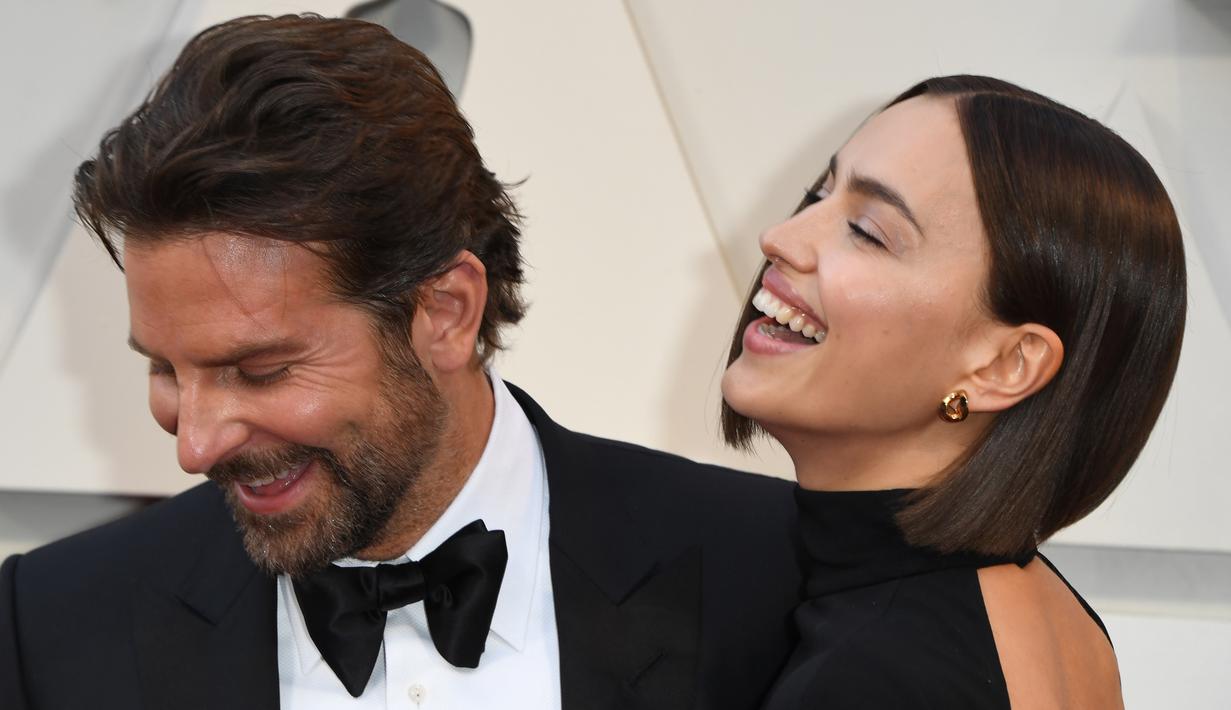 Aktor Bradley Cooper dan pasangannya, Irina Shayk  menghadiri perhelatan Oscar 2019 di Dolby Theatre, Los Angeles, Minggu (24/2). Bradley Cooper begitu mesra dengan Irina yang terlihat sangat cantik menawan di acara tersebut. (Mark RALSTON / AFP)
