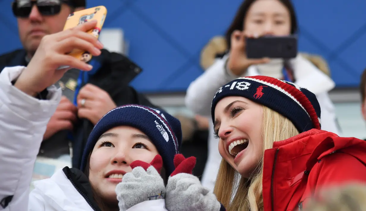 Putri Presiden AS Donald Trump yang juga penasihat senior Gedung Putih, Ivanka Trump (kanan) berswafoto dengan atlet Korea Selatan saat menonton snowboard pria pada Olimpiade Musim Dingin Pyeongchang 2018, Korea Selatan, Sabtu (24/2). (Ed JONES/AFP)