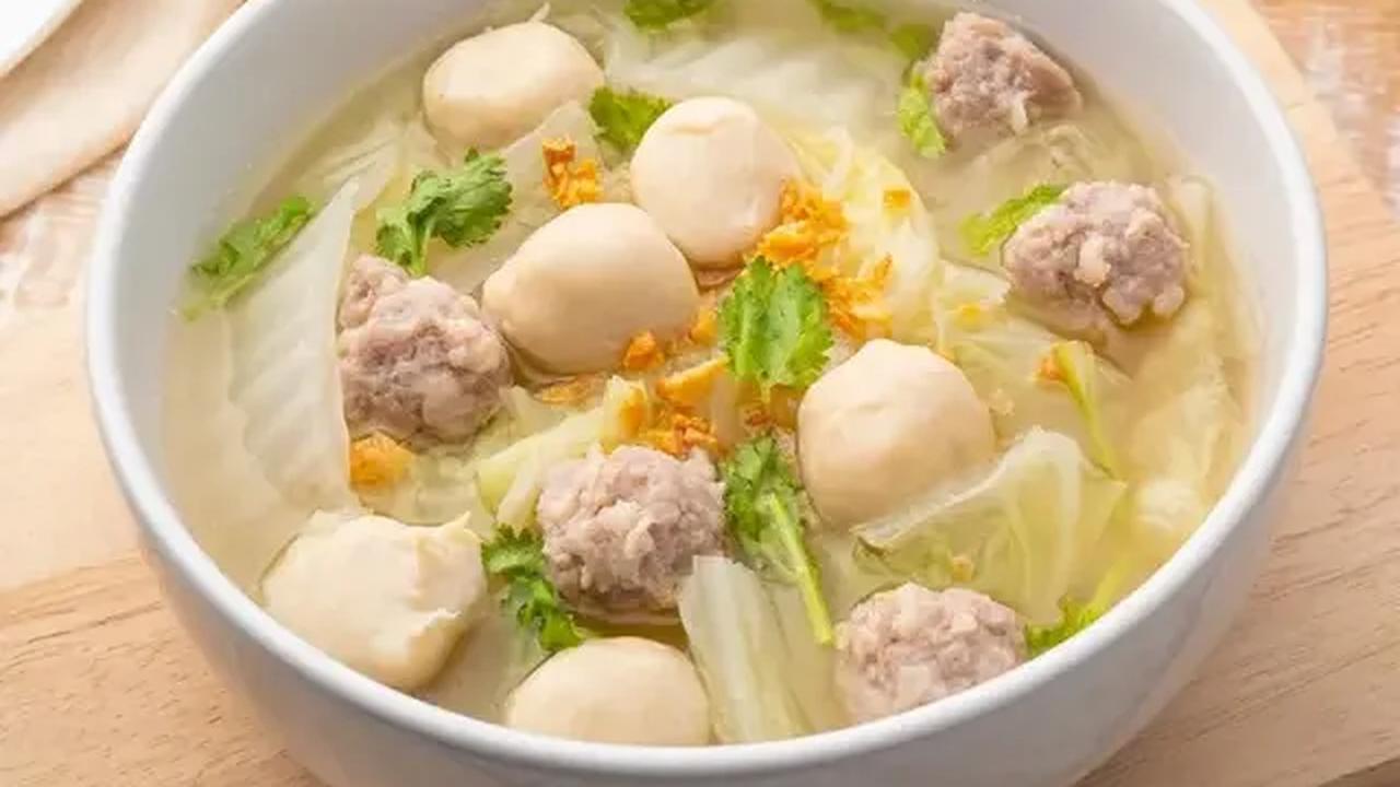 Suami Yenny dengan cekatan menyiapkan meja, panci elektrik, setumpuk mangkung kertas, dan untuk beberapa bahan pelengkap bakso.
