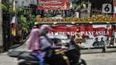 Pengendara sepeda motor melintas di depan salah satu pintu masuk Kampung Bali saat perayaan Hari Nyepi, Harapan Jaya, Bekasi, Jawa Barat, Minggu (14/3/2021). Toleransi beragama untuk saling menghormati di kampung ini sangat terjaga. (merdeka.com/Iqbal S. Nugroho)