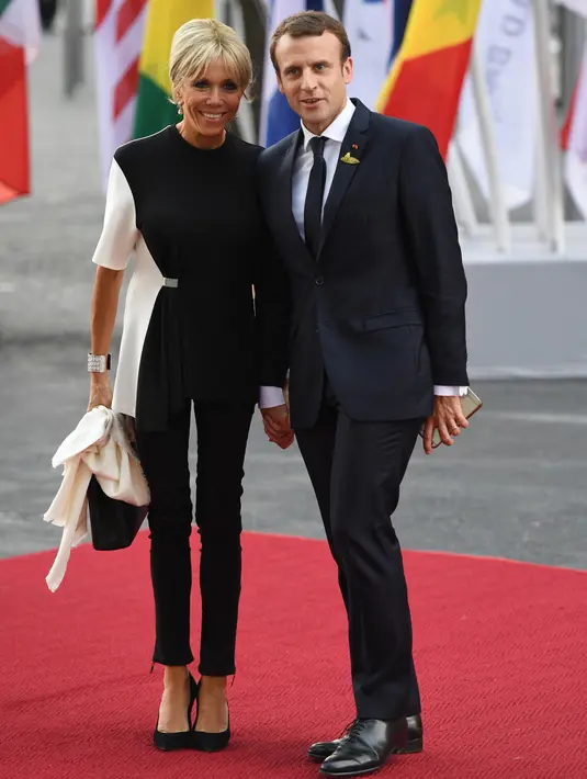 Presiden Prancis Emmanuel Macron dan istrinya Brigitte Macron tiba menghadiri KTT G20 di Hamburg, Jerman, (7/7). Sejumlah pemimpin negara berkumpul dalam KTT G20 pada 7-8 Juli 2017. (AFP Photo/Patrik Stollarz)