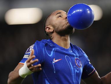 Pemain Chelsea, Christopher Nkunku melakukan selebrasi dengan meniup balon setelah mencetak gol ke gawang Southampton dalam laga lanjutan Liga Inggris 2024/2025 di Stamford Bridge, London, Rabu (26/02/2025) WIB. (AP Photo/John Walton)