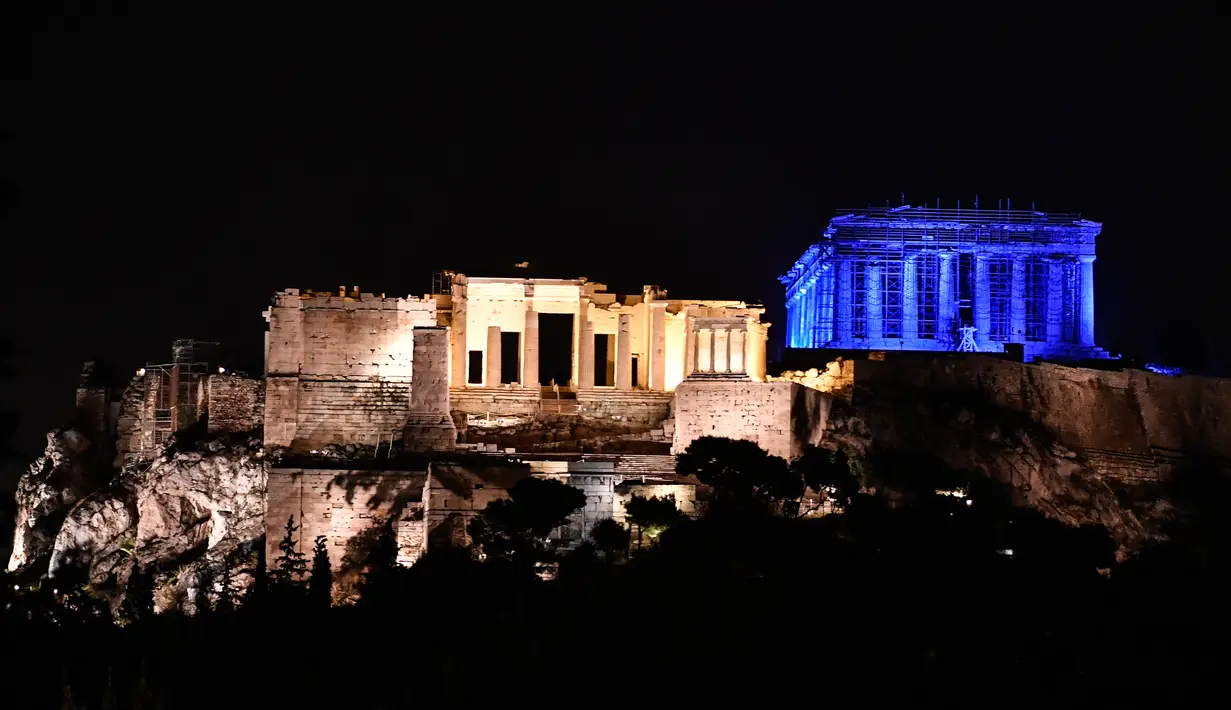 Situs warisan dunia Kuil Parthenon berwarna biru saat Hari Anak Sedunia, Athena, Yunani, Rabu (20/11/2019). Nuansa biru pada kuil yang berada di puncak bukit Acropolis tersebut untuk memperingati Hari Anak Sedunia yang jatuh setiap tanggal 20 November. (LOUISA GOULIAMAKI/AFP)