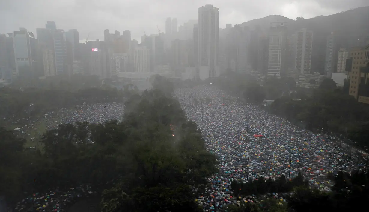 Pengunjuk rasa berkumpul di Victoria Park, Hong Kong, Minggu (18/8/2019). Puluhan ribu massa pro-demokrasi membawa payung saat hujan mengguyur Victoria Park dan sekitarnya. (AP Photo/Kin Cheung)