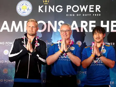 Pelatih Leicester City Claudio Ranieri bersama kiper Kasper Schmeichel dan Shinji Okazaki mengucapkan salam tradisional saat tiba di Bandara Internasional Suvarnabhumi, Bangkok, Thailand, (18/5). (REUTERS/Athit Perawongmetha)