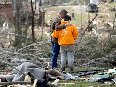 Gubernur Tennessee Bill Lee (kiri) berdoa bersama Kayla Cowen yang sedang mencari tetangganya setelah tornado menerjang Cookeville, Tennessee, Amerika Serikat, Selasa (3/3/2020). Tornado yang menerjang Tennessee menewaskan 25 orang. (AP Photo/Mark Humphrey)
