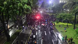 Massa aksi yang berunjuk rasa di depan Markas Polda Metro Jaya, Jakarta, berangsur membubarkan diri bersamaan dengan hujan deras di kawasan itu pada Jumat (29/8/2025) malam. (merdeka.com/Arie Basuki)