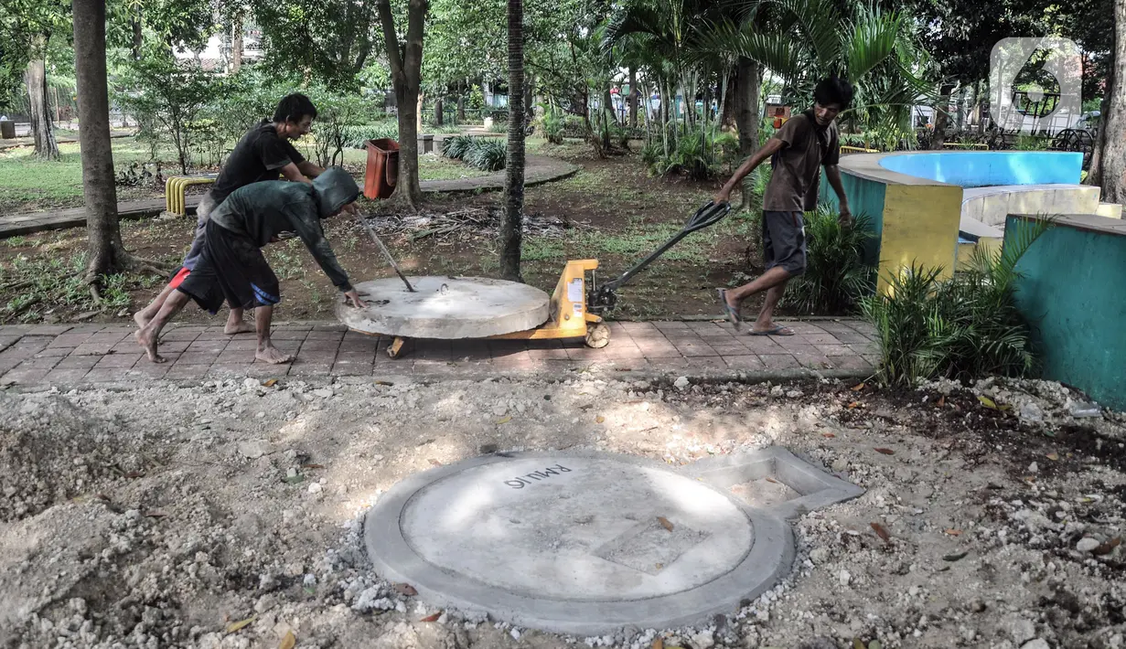 Pekerja menyelesaikan pembangunan sumur resapan di RPTRA Meruya Utara, Jakarta, Selasa (25/1/2022). Pembangunan 100 titik sumur resapan ini bertujuan untuk mengantisipasi banjir yang kerap terjadi di wilayah tersebut. (merdeka.com/Iqbal S. Nugroho)