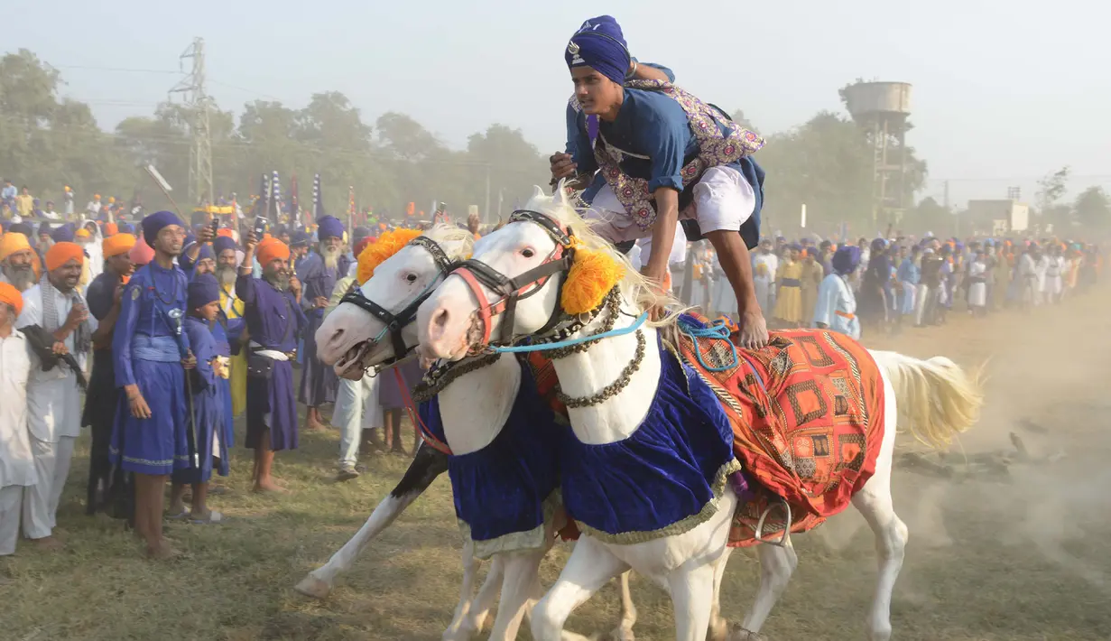 Atraksi berkuda dari anggota militer tradisional Sikh saat perayaan Fateh Divas di Amritsar (20/10). Para anggota militer ini menujukan aksi berkuda mereka untuk meramaikan perayaan Fateh Divas. (AFP/Narinder Nanu)