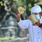 Pemuka Agama Hindu memercikkan air suci saat upacara Melasti menjelang Hari Raya Nyepi Tahun Baru Saka 1943 di Pantai Kuta, Bali (11/3/2021). Ritual Melasti untuk menyucikan alam agar Hari Raya Nyepi dapat berjalan  hening serta damai. (AFP/Sonny Tumbelaka)