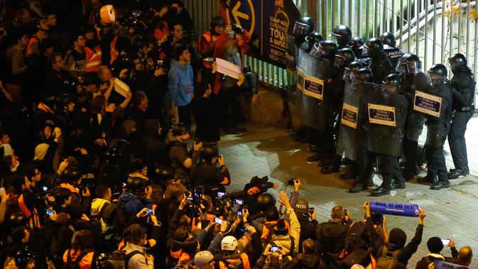 Polisi antihuru-hara berjaga di depan gerbang Camp Nou saat Barcelona bertemu Real Madrid pada El Clasico, Rabu (18/12/2019) (Pau Barrena / AFP)