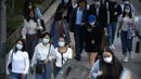Orang-orang memakai masker berjalan di sepanjang jalan di kawasan pusat bisnis di Beijing (16/9/2021).  China pada Kamis (15/9) melaporkan beberapa lusin tambahan kasus virus corona yang ditularkan secara lokal saat berfungsi untuk menahan wabah di provinsi timur Fujian (AP Photo/Mark Schiefelbein)