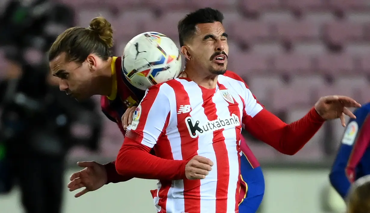 Gelandang Barcelona, Antoine Griezmann (kiri) dan gelandang Athletic Bilbao, Dani Garcia melompat saat bersaing memperebutkan bola pada pekan ke-21 Liga Spanyol 2020/21 di Stadion Camp Nou, Senin (1/2/2021) dini hari WIB. Barcelona sukses mengalahkan Athletic Bilbao dengan skor tipis 2-1. (LLUIS GEN