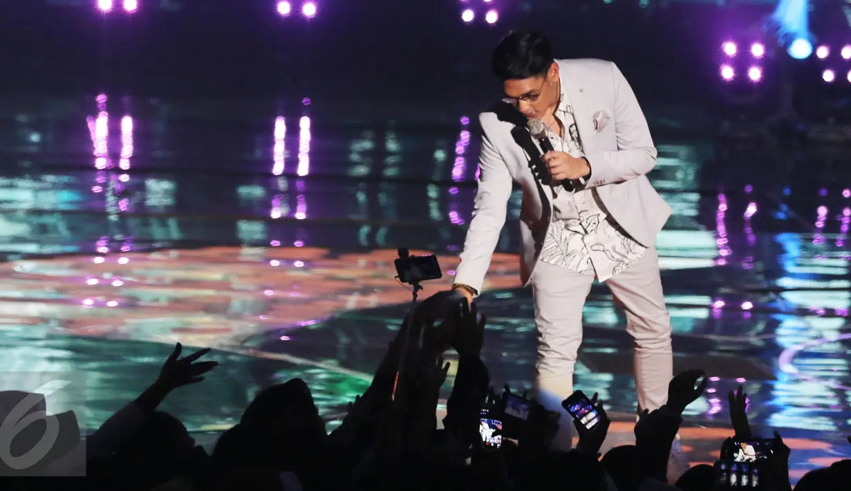 Penyanyi Afgansyah Reza menyapa penonton di atas panggung HUT 26 SCTV di Istora Senayan, Jakarta, Rabu (24/8). Malam itu, Afgan membawakan lagunya yang berjudul 'Kunci Hati'. (Liputan6.com/Herman Zakharia)