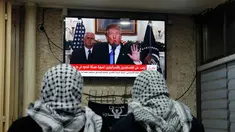 Dua pria Palestina menonton pidato Presiden AS, Donald Trump di sebuah kafe di Yerusalem (6/12). Donald Trump secara resmi mengumumkan bahwa AS mengakui Yerusalem sebagai ibu kota Israel. (AFP Photo/Ahmad Gharabli)
