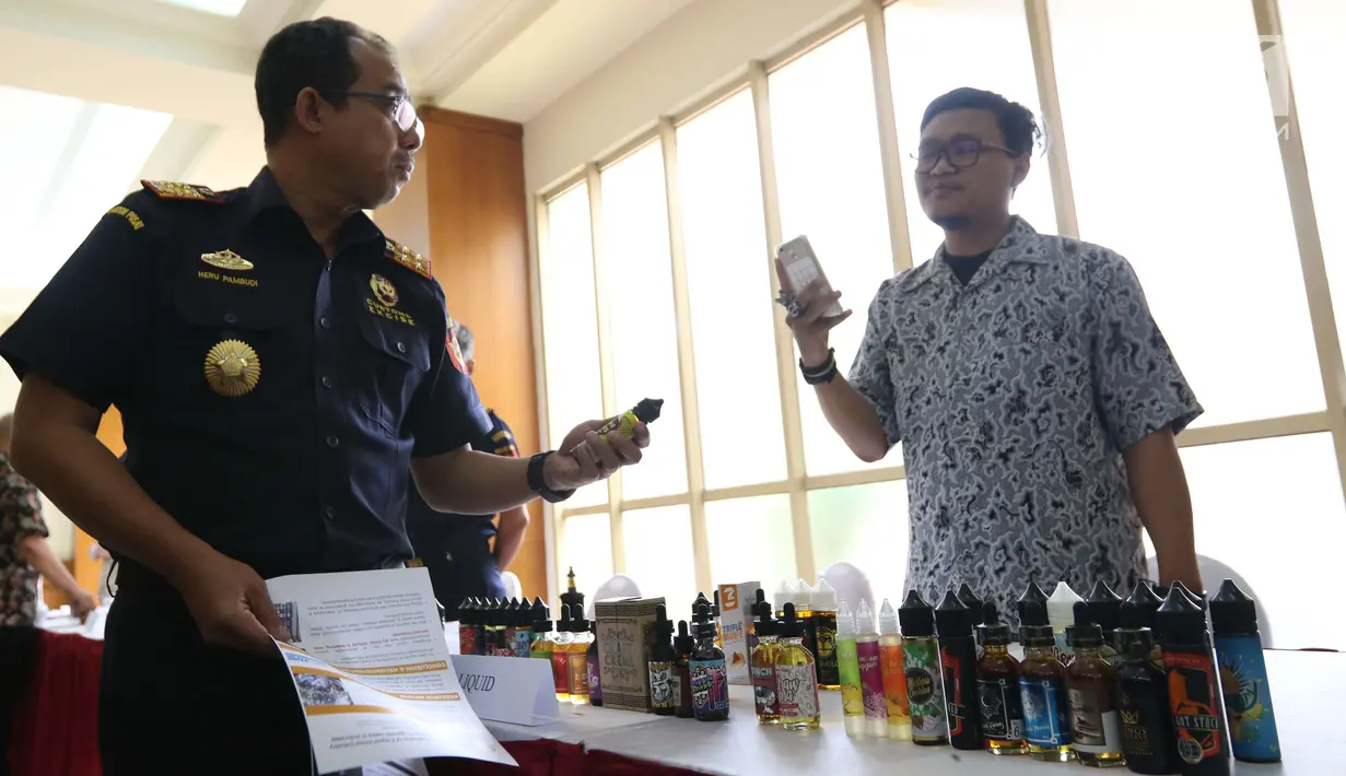 Direktur Jenderal Bea Cukai Heru Pambudi mengecek liquid vape usai memberikan izin perdana berupa Nomor Pokok Pengusaha Barang Kena Cukai (NPPBKC) kepada beberapa pengusaha pabrik liquid vape di Jakarta, Rabu (18/7). (Liputan6.com/Angga Yuniar)