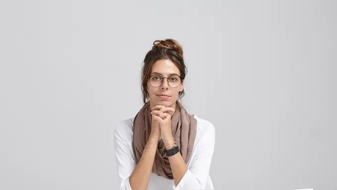 Seorang perempuan sedang menopang dagunya dengan kedua tangan (Foto Dok: Freepik/wayhomestudio)