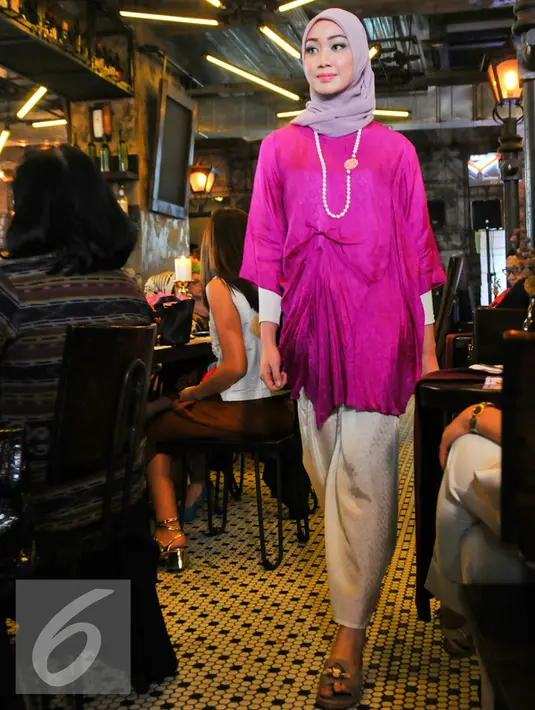 Model berjalan menggenakan kain tenun koleksi terbaru SRI Indonesia saat fashion show, Jakarta, Selasa (17/5). Sri Indonesia menggelar acara trunk show dan lelang baju untuk disumbangkan pada pengrajin tenun dari Garut. (Liputan6.com/Yoppy Renato)