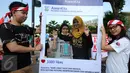 Warga berpose saat mendukung aksi Relawan Komunitas Peduli ASEAN di Jakarta, Minggu (13/3/2016). Relawan ini mengajak masyarakat menggunakan kaos bergambar tentang ke-Indonesia-an dan memposting ke seluruh media sosial. (Liputan6.com/Helmi Fithriansyah)