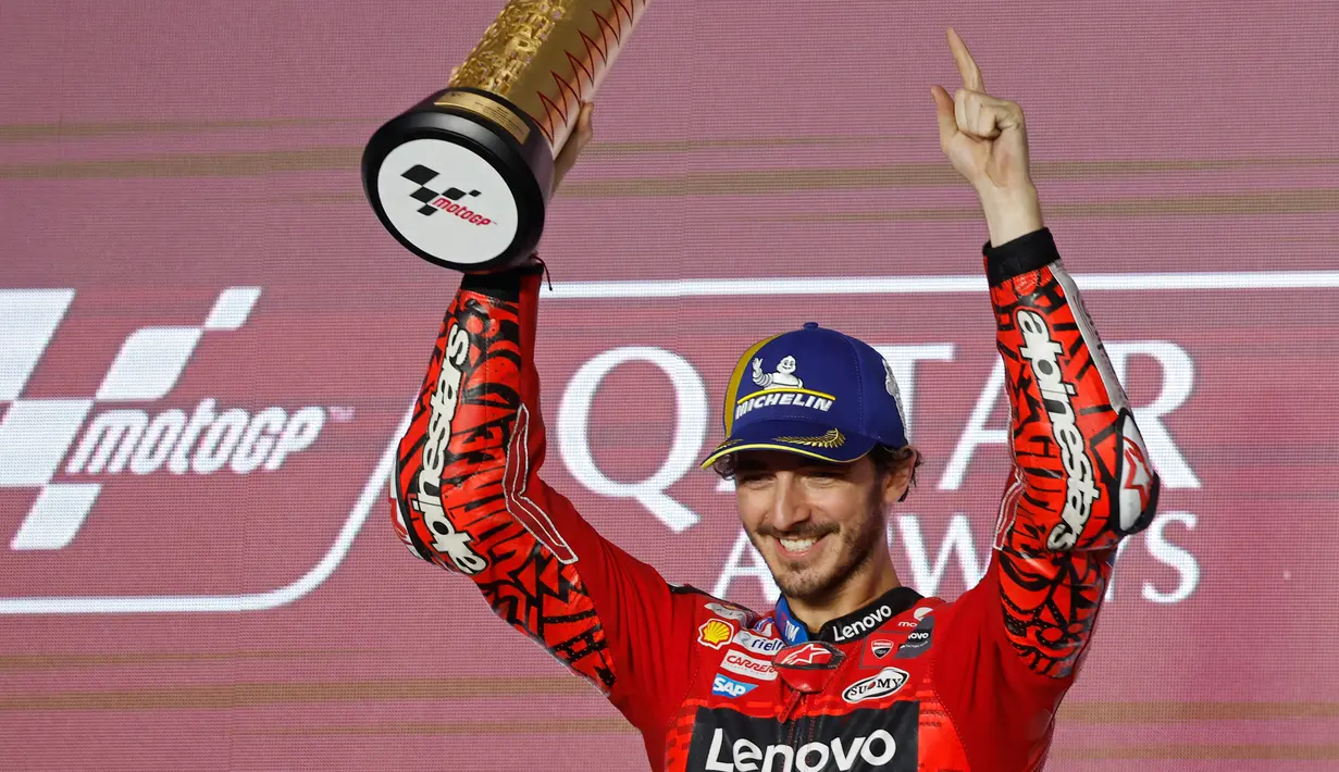 Pembalap Ducati Lenovo Team, Francesco Bagnaia saat merayakan gelar juara di podium MotoGP Qatar di Sirkuit Internasional Lusail, Doha pada 10 Maret 2024. (KARIM JAAFAR/AFP)