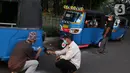 Pengemudi mengecek kondisi bajaj saat tengah menunggu penumpang di kawasan Taman Puring, Jakarta, Minggu (11/7/2021). Dampak dari PPKM darurat membuat penghasilan para pengemudi bajaj menurun drastis hingga 70 pesen. (Liputan6.com/Angga Yuniar)