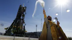 Salah satu pendeta ortodoks melakukan pemberkatan di depan pesawat ruang angkasa Soyuz TMA-14M yang akan lepas landas dari Baikonur Cosmodrome, Kazakhstan, (26/9/2014). (REUTERS/Shamil Zhumatov)