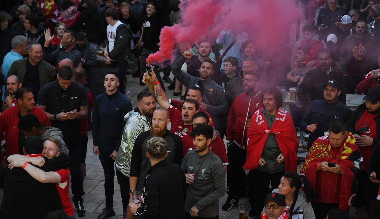 Fans Liverpool merayakan gelar juara Premier League di area Standion Anfield usai pertandingan Liverpool melawan Chelsea, Kamis (23/7/2020) dini hari WIB. Fans Liverpool tetap berdatangan ke area Stadion Anfield meski ada permintaan untuk merayakan di rumah. (AFP/Oli Scarff)