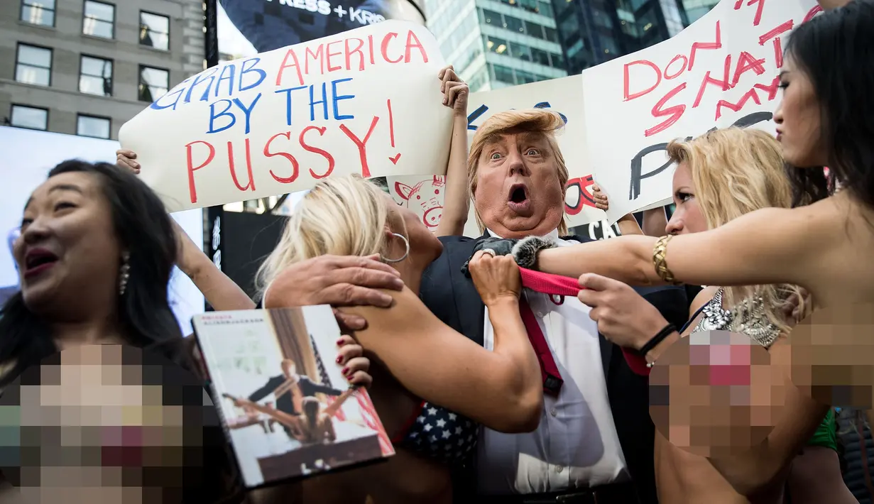Seorang seninam berpenampilan seperti kandidat presiden AS dari Partai Republik Donald Trump melakukan aksi unjuk rasa dengan dikelilingi wanita-wanita seksi berbikini di depan Times Square, New York (25/10). (AFP Photo/Drew Angerer/Getty Images)