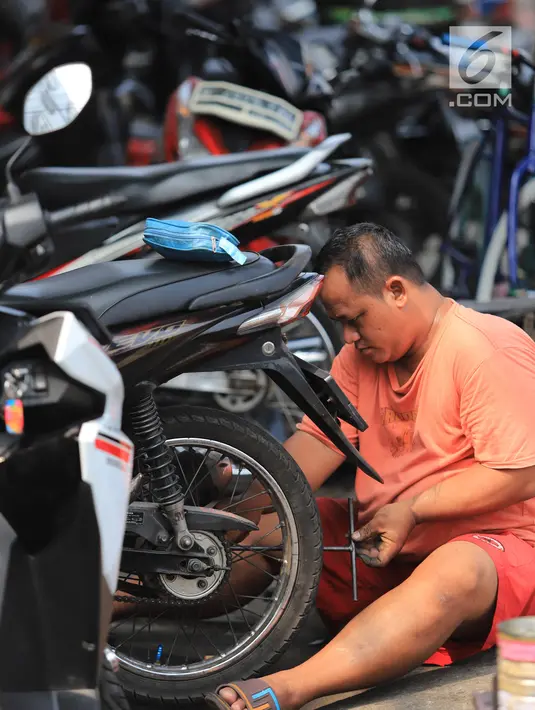 Mekanik memperbaiki motor di salah satu bengkel di Otista, Jakarta, Minggu (10/6). Calon pemudik motor mulai memenuhi bengkel guna menyervis atau mengganti suku cadang kendaraan sebelum digunakan untuk mudik Lebaran. (Liputan6.com/Angga Yuniar)