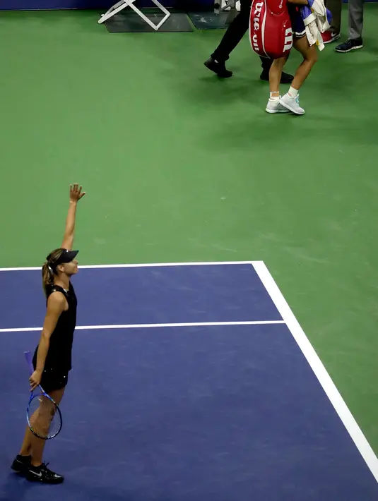 Maria Sharapova menyapa pengemarnya usai pertandingan putaran pertama turnamen tenis AS Terbuka di New York, (28/8). Sharapova menang atas Halep dengan skor 6-4, 4-6, 6-3. (AP Photo/Julio Cortez)