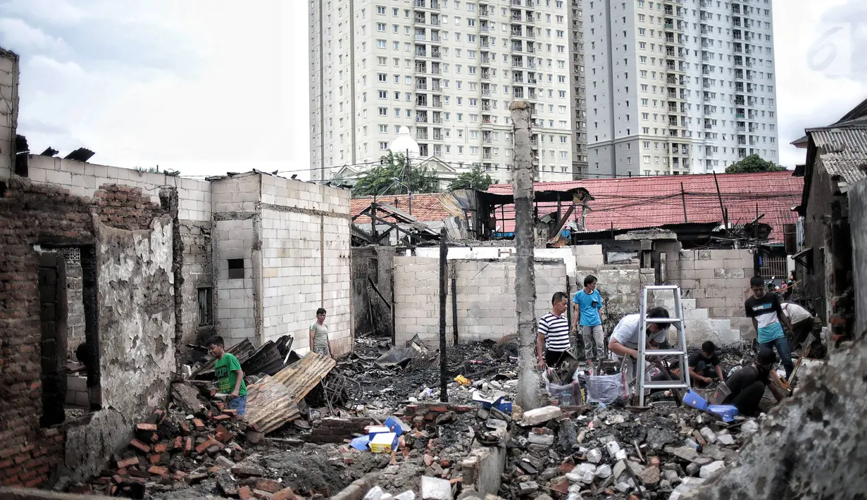 Warga mencari sisa harta benda usai kebakaran menghanguskan Kelurahan Kebon Kosong, Kemayoran, Jakarta, Rabu (26/12). Kebakaran menghanguskan 25 rumah warga Kebon Kosong. (Liputan6.com/Faizal Fanani)