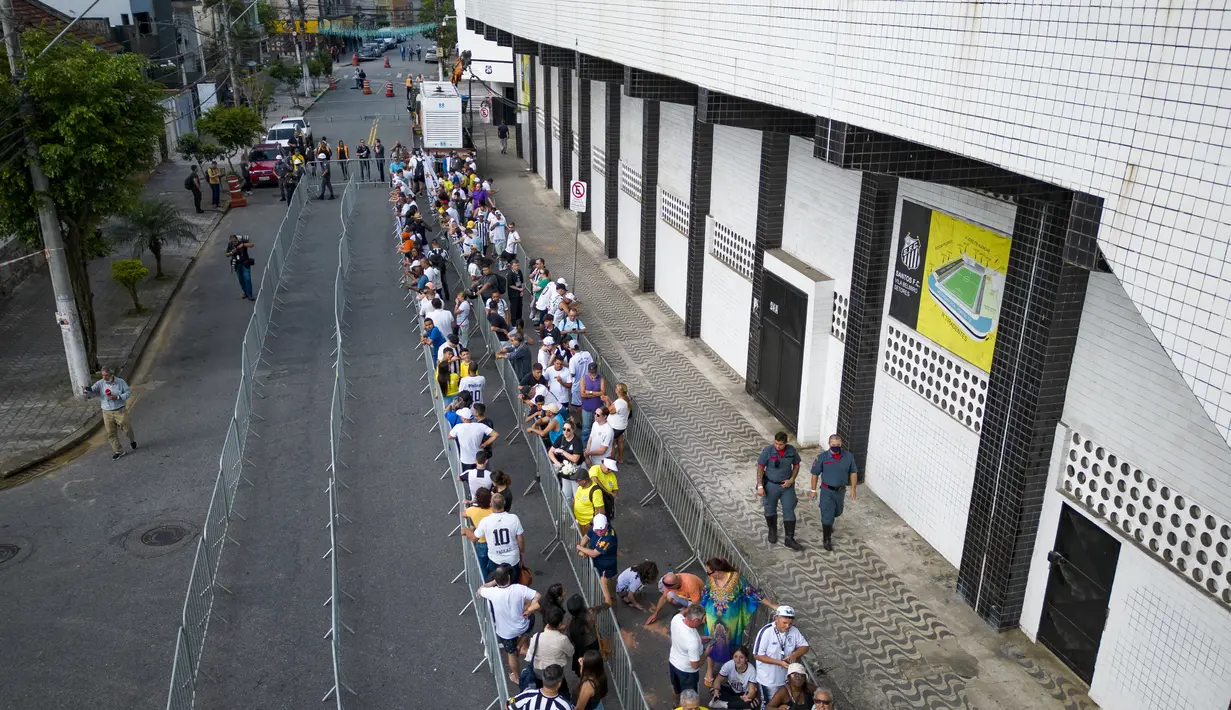 Warga Brasil mengantre untuk memberikan penghormatan terakhir kepada legenda sepak bola Brasil Pele di stadion Vila Belmiro di Santos, Brasil, Senin, 2 Januari 2023. Jenazah Pele akan dimakamkan di Memorial Necropole Ecumenica, kuburan vertikal di Santos. Hanya keluarga yang akan hadir. (AP Photo/Matias Delacroix)