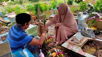Rusdi-Soimah saat berziarah di makam anaknya AM, di TPU Sungai Selayur Palembang Sumsel (Liputan6.com / Nefri Inge)