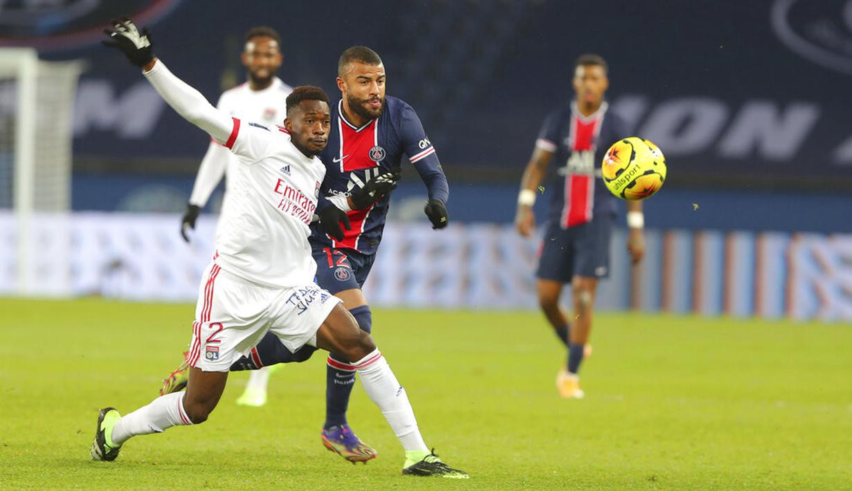 Pemain Lyon Sinaly Diomande (kiri) berebut bola dengan pemain Paris Saint-Germain Rafinha pada pertandingan League One di Stadion Parc des Princes, Paris, Prancis, Minggu (13/12/2020). PSG kalah dari Lyon dengan skor 0-1. (AP Photo/Thibault Camus)