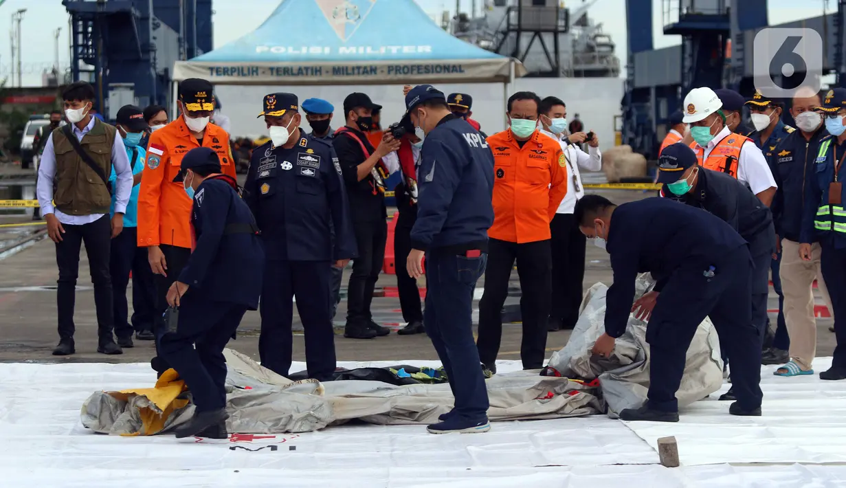 Petugas KPLP dan Basarnas memeriksa barang temuan yang diduga serpihan pesawat Sriwijaya Air SJ 182 di Dermaga JICT 2, Jakarta, Minggu (10/1/2021). Sriwijaya Air SJ 182 hilang kontak dalam penerbangan dari Jakarta menuju Pontianak. (Liputan6.com/Helmi Fithriansyah)