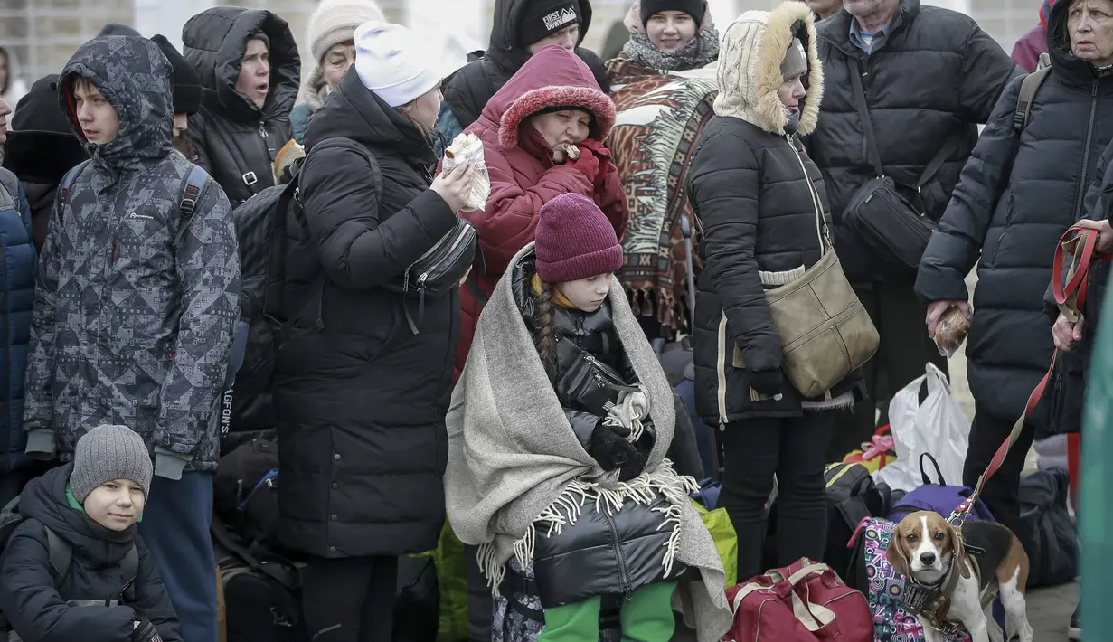 Orang-orang yang meninggalkan Ukraina menunggu bus untuk menuju stasiun kereta api di Przemysl, di perbatasan di Medyka, Polandia, Jumat (4/3/2022). PBB pada Kamis (3/3) melaporkan 1 juta orang telah meninggalkan Ukraina sejak invasi Rusia terhadap negara itu sepekan lalu. (AP Photo/Visar Kryeziu)
