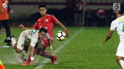 Gelandang Persija, Novri Setiawan mencoba menahan pemain Persebaya, Abu Rizal Maulana pada lanjutan Go-Jek Liga 1 Indonesia 2018 bersama Bukalapak di Lapangan PTIK, Jakarta, Selasa (26/6). (Liputan6.com/Helmi Fithriansyah)