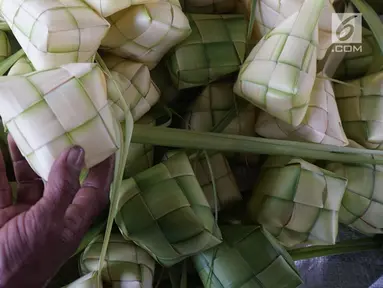 Pedagang menata kulit ketupat yang dijual di kawasan Bintaro, Jakarta, Sabtu (10/8/2019). Menjelang Idul Adha, para pedagang menjual kulit ketupat dengan harga sekitar Rp 8 ribu per sepuluh buah tergantung ukuran. (Liputan6.com/Herman Zakharia)