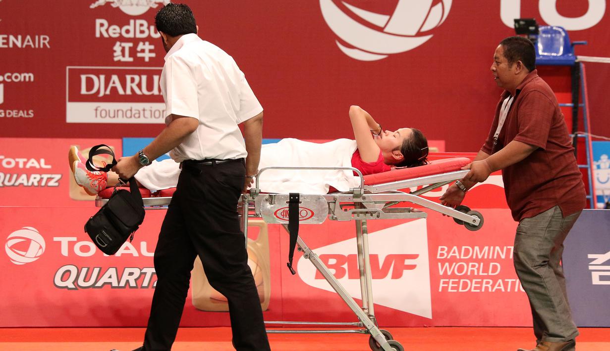 Ratchanok Intanon, dibawa keluar lapangan dengan meja dorong setelah mengalami cedera kaki kanan. Kamis (13/8/2015). (Bola.com/Arief Bagus)