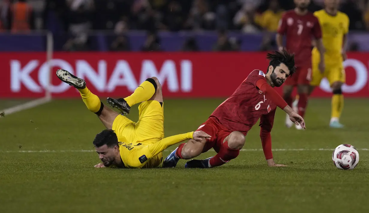 Striker Malaysia, Paulo Josue (kiri) dan gelandang Bahrain, Mohammed Al Hardan terjatuh saat perebutan bola pada laga kedua Grup E Piala Asia 2023 di Jassim bin Hamad Stadium, Al Rayyan, Qatar, Sabtu (20/1/2024) sore waktu setempat. (AP Photo/Thanassis Stavrakis)