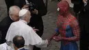 Paus Fransiskus bertemu Spider-Man, yang memberinya masker, pada akhir audiensi umum mingguan dengan jumlah umat terbatas di San Damaso Courtyard, Vatikan, Rabu (23/6/2021). Pria itu adalah Mattia Villardita (27) dari Italia utara yang menghibur anak-anak di rumah sakit. (AP Photo/Andrew Medichini)