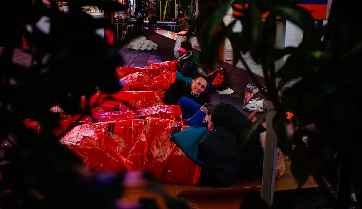 Orang-orang bersiap-siap untuk tidur di area terbuka dalam acara World's Big Sleep Out di Times Square, New York, 7 Desember 2019. Aksi di beberapa kota besar dunia ini sebagai bagian dari upaya penggalangan dana untuk membantu para tunawisma di banyak negara. (Eduardo Munoz Alvarez/AFP)