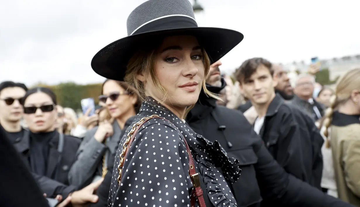 Shailene Woodley tiba menghadiri acara busana ready-to-wear Spring/Summer 2023 Dior yang dipresentasikan di Paris, Selasa, 27 September 2022. Shailene tampil dalam balutan kemeja hitam polkadot dan celana setelan cokelat berpinggang tinggi dengan kawat gigi hitam terpasang di bahunya. (AP Photo/Lewis Joly)